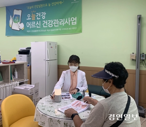AI·IoT 기반 어르신 건강 관리 서비스 ‘오늘 건강’ 시범사업은 만성질환이 있는 65세 이상 어르신에게 블루투스 기기와 스마트폰을 연동해 혈압·혈당·체중 등을 확인하도록 도와주고, 말 벗이 되어주는 AI 생활 스피커를 제공하는 자가 건강 관리 사업이다. 한 어르신이 보건소 관계자와 스마트폰을 활용한 소통방식에 대해 상담을 하고 있다. /평택시 제공