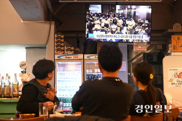 윤석열 대통령이 비상계엄령을 선포한 3일 밤 수원시 권선구의 한 점포에서 시민들이 실시간 국회 상황 뉴스를 시청하고 있다. 2024.12.4 /최은성기자 ces7198@kyeongin.com