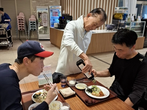 한주식 회장이 식사 중인 직원들의 음식에 “석류가 몸에 좋다”며 석류드레싱을 뿌려주고 있다.
