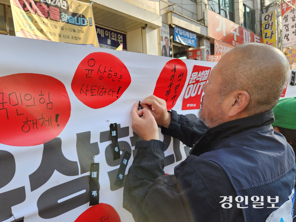 10일 오전 인천 미추홀구 윤상현 의원 인천사무실 앞 가로수에 걸린 사퇴촉구 현수막에 시민이 근조리본을 걸고 있다. 2024.12.10/유진주기자 yoopearl@kyeongi