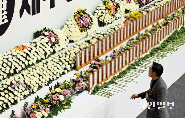 30일 오후 전남 무안종합스포츠파크에 마련된 제주항공 여객기 희생자 합동분향소에서 한 조문객이 희생자 명패를 바라보고 있다. 2024.12.30 /이지훈기자 jhlee@kyeongin.com