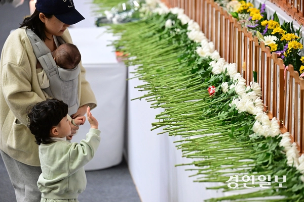 제주항공여객기참사 발생 이틀째인 30일 오후 전남 무안종합스포츠파크에 차려진 합동분향소에서 한 아이가 희생된 3세 아동에게 손인사를 하고 있다. 2024.12.30 /이지훈기자 jhlee@kyeongin.com