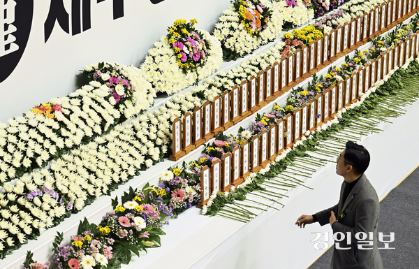 30일 오후 전남 무안종합스포츠파크에 마련된 제주항공 여객기 희생자 합동분향소에서 한 조문객이 희생자 명패를 바라보고 있다. 2024.12.30 /이지훈기자 jhlee@kyeongin.com