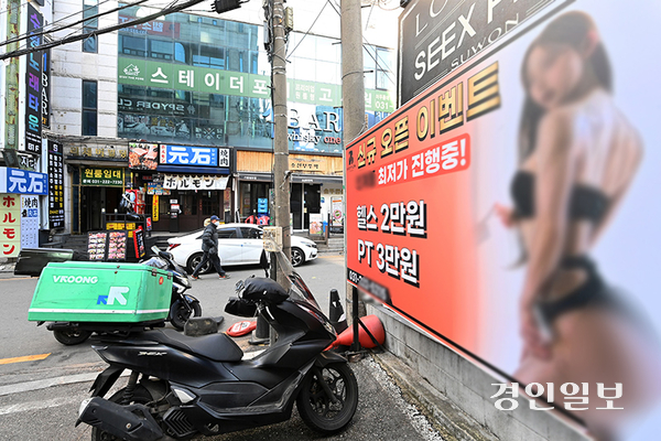 9일 오후 수원시 팔달구 인계동의 한 거리에 선정적인 헬스광고 입간판이 설치돼 있어 시민들의 눈살을 찌푸리게 하고 있다. 2025.1.9 /최은성기자 ces7198@kyeongin.com