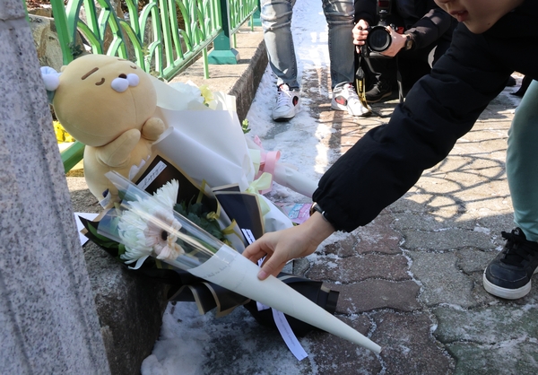 11일 오전 초등생 1학년 여아가 살해당한 대전 서구 한 초등학교 앞에서 한 아동이 국화꽃을 두고 추모하고 있다. 2025.2.11 /연합뉴스