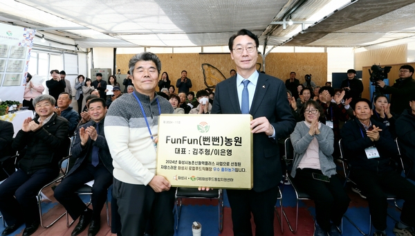 정명근 화성시장이 로컬푸드 직매장 우수농가로 선정된 김주형씨에게  현판을 전달하고 있다. /화성시 제공