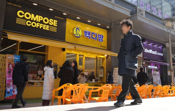 원두 가격 상승에 따라 커피 전문점의 가격 인상이 잇따르는 가운데 21일 저가 커피 판매점이 밀집한 서울 종로구의 한 상가 앞으로 시민이 걸어가고 있다. 2025.2.21 /연합뉴스