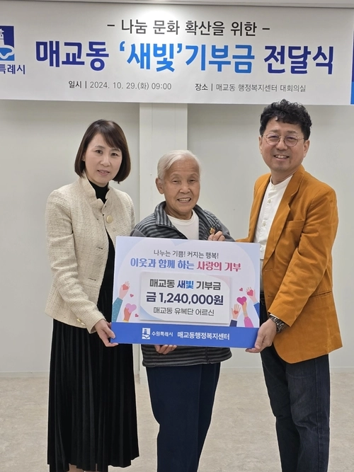 매교동 주민인 유복단 할머니(가운데)가 폐지를 팔아 모은 금액을 새벽빛 장애인학교 이전을 위해 기부하고 있다. /수원시 제공