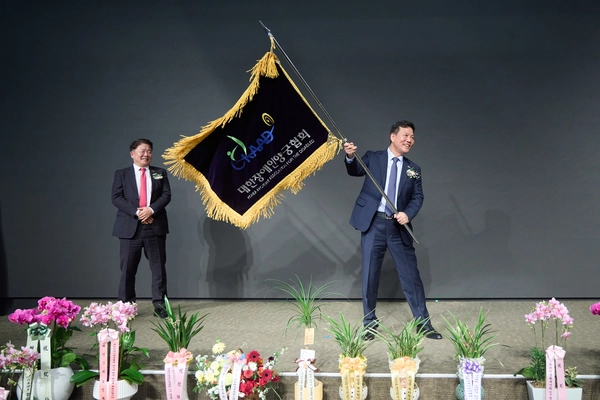 고광만(오른쪽) 대한장애인양궁협회 신임 회장이 이경렬 이임회장에게 전달받은 협회깃발를 흔들며 미소 짓고 있다. 2025.3.5 / 여주시 제공