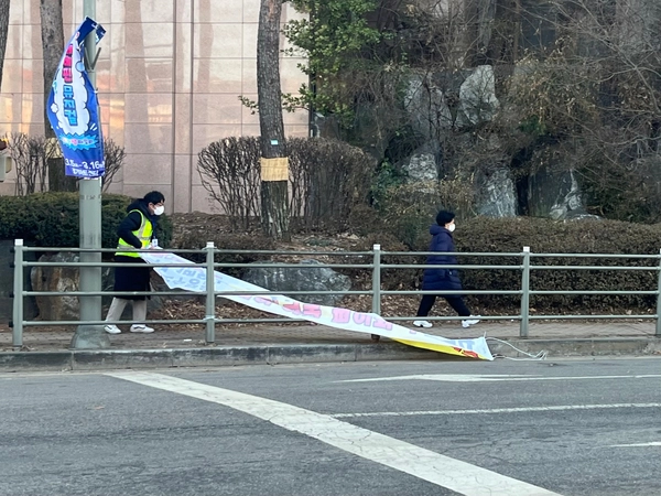 용인시가 전국 최초로 도입한 시민수거단원들이 불법 현수막을 수거하고 있다./용인특례시 제공