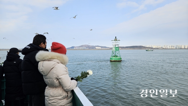 설 연휴 마지막 날인 지난 1월 30일 오전 현대유람선 추모 배에 오른 성묘객이 부표를 향해 헌화하고 있다. 2025.1.30 /김희연기자 khy@kyeongin.com
