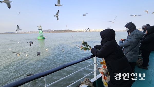 설 연휴 마지막 날인 지난 1월 30일 오전 현대유람선 추모 배에 오른 성묘객이 부표를 향해 헌화하고 있다. 2025.1.30 /김희연기자 khy@kyeongin.com