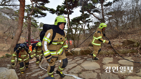 26일 오후 인천시 강화군 길상면 전등사 인근 등산로에서 인천소방본부 강화소방서 소속 소방대원들이 소방장비를 메고 화재 훈련을 하고 있다. 이날 산불 진화훈련은 최근 전국 산불 재난 위기 경보가 ‘심각’ 단계로 격상되면서 문화재 화재 예방 등을 위해 실시했다. 2025.3.26 /조재현기자 jhc@kyeongin.com