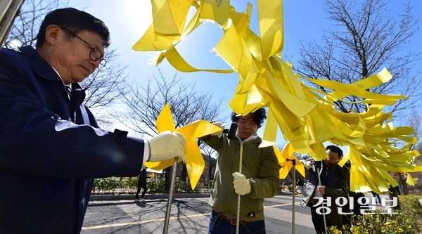 세월호 참사 11주기를 앞둔 29일 오후 인천시 부평구 인천가족공원 내 세월호 일반인 희생자 추모관에서 도성훈 인천시교육감, 전태호 세월호일반인유가족협의회 위원장 등 참석자들이 세월호 희생자를 추모하는 의미의 노란색 바람개비를 설치하는 ‘노랑 드레 언덕’을 만들고 있다. 2025.3.29 /조재현기자 jhc@kyeongin.com
