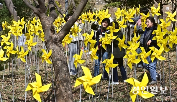 세월호 참사 11주기를 앞둔 29일 오후 인천시 부평구 인천가족공원 내 세월호 일반인 희생자 추모관에서 희생자를 추모하는 의미의 노란색 바람개비를 설치하는 ‘노랑 드레 언덕’행사에 참석한 참가자들이 바람개비를 설치하고 있다. 2025.3.29 /조재현기자 jhc@kyeongin.com