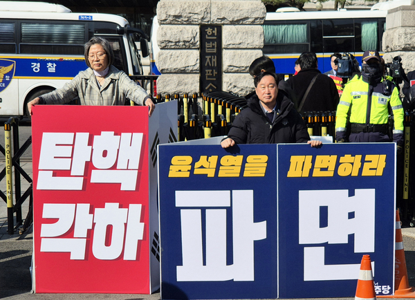 31일 오전 서울 종로구 헌법재판소 앞에서 더불어민주당 수원정 김준혁 국회의원(오른쪽)과 같은 지역구 국민의힘 이수정 당협위원장이 각각 ‘윤석열 파면 촉구’와 ‘탄핵각하’ 피켓을 들고 1인 시위를 하고 있다. /더불어민주당 제공