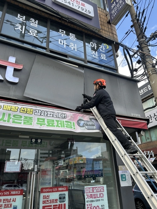 소방대원이 강풍으로 떨어진 간판을 안전조치 하고 있다. /인천소방본부 제공