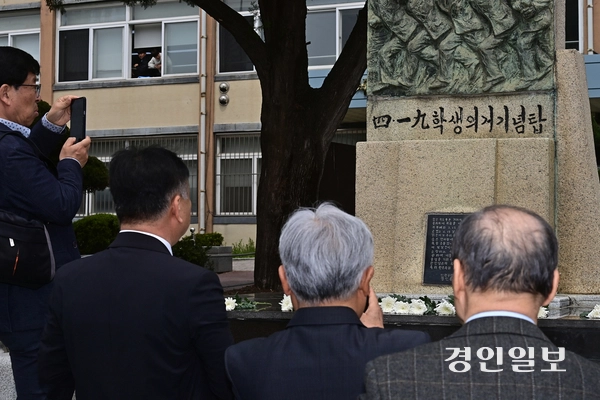 18일 오전 인천시 미추홀구 인천기계공업고등학교에서 열린 제65주년 4·19혁명 기념식에 참석한 졸업생들이 4.19 학생 의거 기념탑을 사진으로 담고 있다. 2025.4.18 /조재현기자 jhc@kyeongin.com