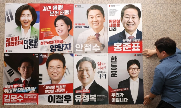 20일 서울 여의도 국회 본청 국민의힘 사무실 앞에 당 관계자가 대선 경선 후보자 포스터를 붙이고 있다. 2025.4.20 /연합뉴스