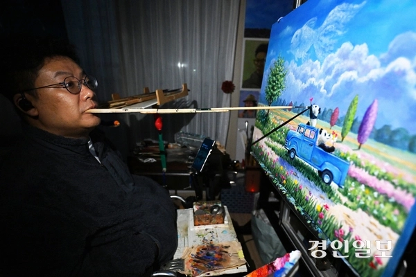 장애인의 날인 20일 오후 구족화가 임경식 작가가 인천 자택 작업실에서 입에 붓을 물고 ‘꿈을 꾸다’ 연작 그림을 그리고 있다. 19세 때 불의의 교통사고로 지체장애인이 된 임작가는 13년간 은둔생활을 하다가 입으로 그림을 그리는 방식으로, 장애를 극복하고 예술적 재능을 발휘하고 있다. 그의 작품은 장애인 예술가들에게도 큰 희망이 되고 있으며 사회적 인식 개선에도 기여 하고 있다. 그는 “세상과 소통하고 사회 구성원으로 살기 위해 꾸준히 그림을 그리는 게 꿈이다. 장애인에 대한 차별과 편견 없이 내면을 먼저 봐 주시면 좋겠다.”라고 말했다. 2025.4.20 /임열수기자 pplys@kyeongin.com