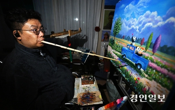 장애인의 날인 20일 오후 구족화가 임경식 작가가 인천 자택 작업실에서 입에 붓을 물고 ‘꿈을 꾸다’ 연작 그림을 그리고 있다. 19세 때 불의의 교통사고로 지체장애인이 된 임작가는 13년간 은둔생활을 하다가 입으로 그림을 그리는 방식으로, 장애를 극복하고 예술적 재능을 발휘하고 있다. 그의 작품은 장애인 예술가들에게도 큰 희망이 되고 있으며 사회적 인식 개선에도 기여 하고 있다. 그는 “세상과 소통하고 사회 구성원으로 살기 위해 꾸준히 그림을 그리는 게 꿈이다. 장애인에 대한 차별과 편견 없이 내면을 먼저 봐 주시면 좋겠다.”라고 말했다. 2025.4.20 /임열수기자 pplys@kyeongin.com