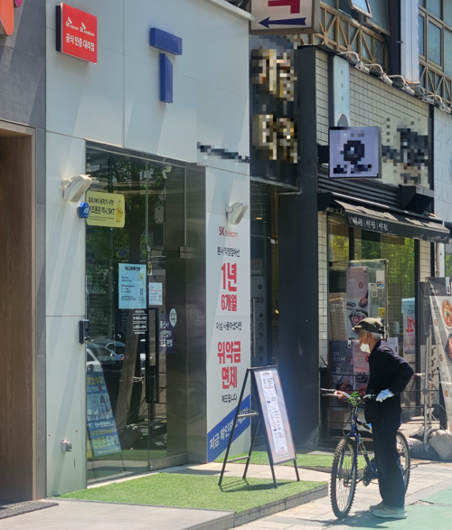 29일 수원시의 한 SKT 직영점 앞에서 한 노인이 유심 교환 안내문을 보고 있다. 2025.4.29 /김지원기자 zone@kyeongin.com