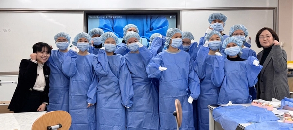 서정대학교 간호학과의 진로체험 프로그램에 참여한 양주 덕정고등학교 학생들이 수술실 가운을 입고 간호학과 교수들과 기념촬영을 하고 있다. 2025.4.29 /서정대 제공