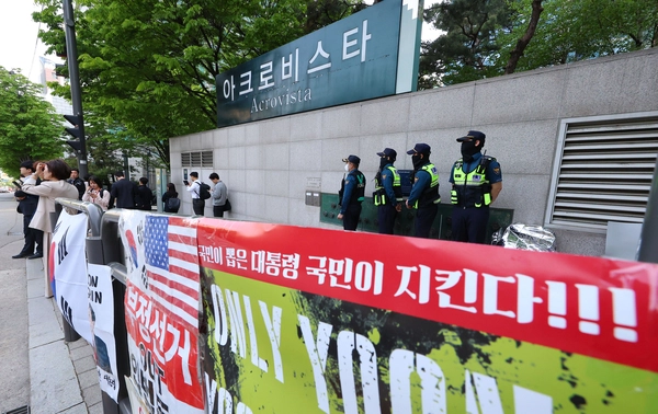 윤석열 전 대통령 부부와 건진법사 전성배씨 사이의 각종 의혹을 수사 중인 검찰이 윤 전 대통령의 사저에 대해 압수수색에 들어간 30일 서울 서초구 아크로비스타 앞에서 경찰이 대기하고 있다. 검찰은 통일교 고위 인사가 건진법사 전씨에게 김건희 여사 선물 명목으로 다이아몬드 목걸이뿐 아니라 고가의 가방까지 전달한 정황을 추적 중인 것으로 전해졌다. 특히 통일교 전 세계본부장 윤모씨가 윤 전 대통령 당선 직후 전씨에게 가방 역시 건넸다는 정황을 포착하고 그 진위와 실제 김 여사에게 전달됐는지 등을 확인 중인 것으로 파악됐다. 2025.4.30 /연합뉴스