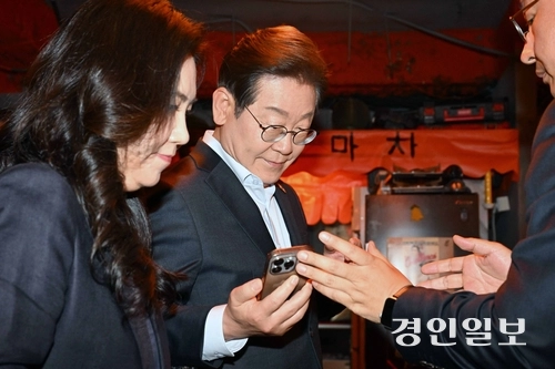 이재명 더불어민주당 대선 후보가 1일 서울 종로구의 한 음식점에서 열린 비전형 노동자 간담회 종료 후 당 관계자에게 전달받은 휴대전화를 확인하고 있다. 대법원 전원합의체는 이날 이 후보에게 무죄를 선고한 원심판결을 파기하고 사건을 서울고법으로 돌려보냈다. 2025.5.1 /최은성기자 ces7198@kyeongin.com