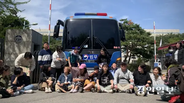 지난달 23일 오후 1시30분께 화성외국인보호소 앞에서 난민신청자 강제송환에 반대하는 시민단체 활동가들이 법무부 소속 호송버스 앞을 가로막고 앉아 저지 시위를 벌이고 있다. 활동가들은 호송 대상자의 탑승 여부 확인을 요구하며 송환 중단을 촉구했고, 현장에서는 경찰과의 대치가 이어졌다. 2025.4.23 /유혜연기자 pi@kyeongin.com