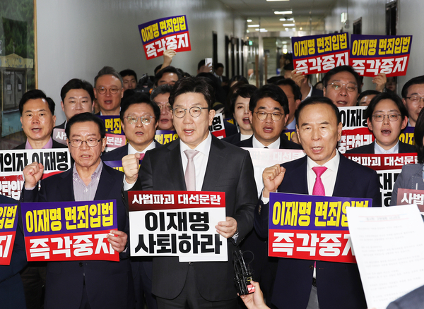 7일 서울 여의도 국회 법제사법위원회 전체회의장 앞에서 국민의힘 의원들이 ‘이재명 면죄입법 즉각중지’ 등의 내용이 적힌 손팻말을 들고 구호를 외치고 있다. 국회 법제사법위원회는 이날 법안심사소위원회를 열어 대통령 당선 시 진행 중인 형사재판을 정지하도록 하는 내용의 형사소송법 개정안을 의결했다. 2025.5.7 /연합뉴스