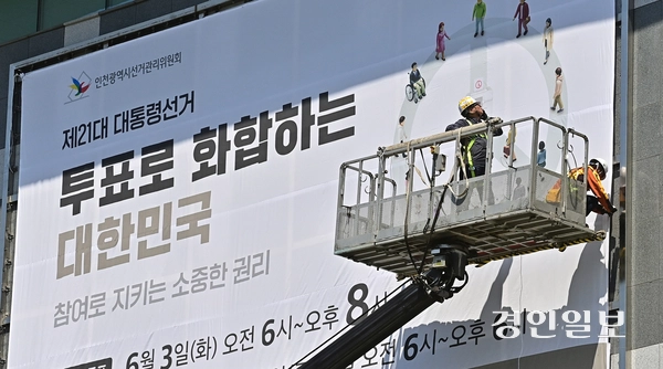 7일 오전 인천시 미추홀구 인천시선거관리위원회 외벽에 제21대 대통령선거 투표일과 사전 투표일을 알리는 대형 현수막이 설치되고 있다. 2025.5.7 /조재현기자 jhc@kyeongin.com