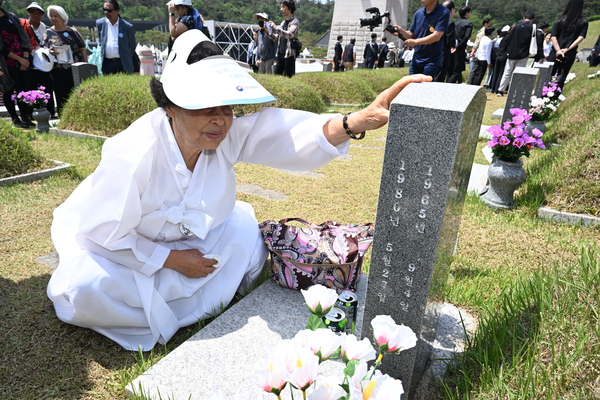 18일 오전 광주 북구 5·18 민주묘지에서 제45주년 5·18 민주화운동 기념식을 마친 유족이 묘비를 어루만지고 있다. 2025.5.18 /공동취재