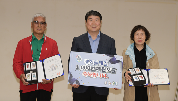 경기둘레길 전구간 1천번째 완보자인 이은영씨 부부가 조원용 경기관광공사 사장과 기념 촬영을 하고 있다. /경기관광공사 제공.