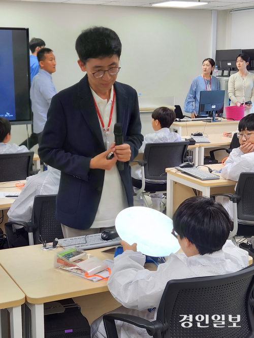 21일 한국세라믹기술원 이천분원에서 반도체 공유학교 수업이 열린 가운데 SK하이닉스 관계자가 학생에게 반도체 웨이퍼를 설명하고 있다. 김형욱기자 /uk@kyeongin.com
