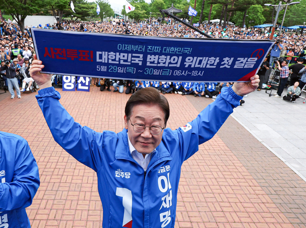더불어민주당 이재명 대선 후보가 22일 경남 양산워터파크공원에서 열린 집중유세에서 ‘사전투표! 대한민국 변화의 위대한 첫걸음’이라고 적힌 현수막을 들어 보이고 있다. 2025.5.22 /연합뉴스