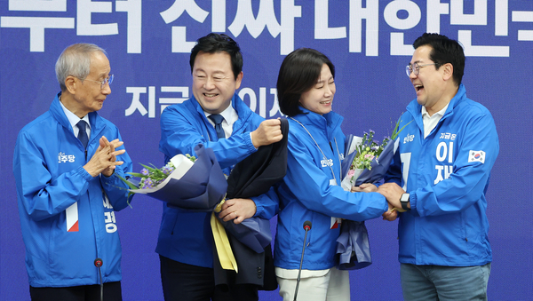 더불어민주당 박찬대 대표 직무대행 겸 원내대표와 윤여준 총괄선대위원장이 26일 서울 여의도 당사에서 열린 선대위 회의에서 허은아(오른쪽 두번째), 김용남 전 의원에게 선거운동복을 입혀주고 있다. 2025.5.26 /연합뉴스