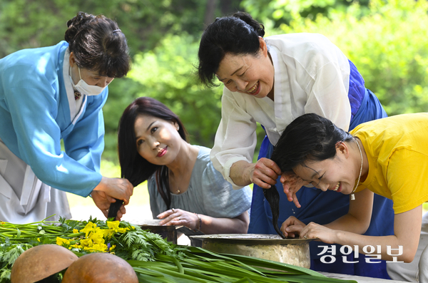 단오를 이틀 앞둔 29일 용인시 기흥구 한국민속촌에서 관광객들이 창포물 머리 감기 체험을 하고 있다. 2025.5.29 /이지훈기자 jhlee@kyeongin.com