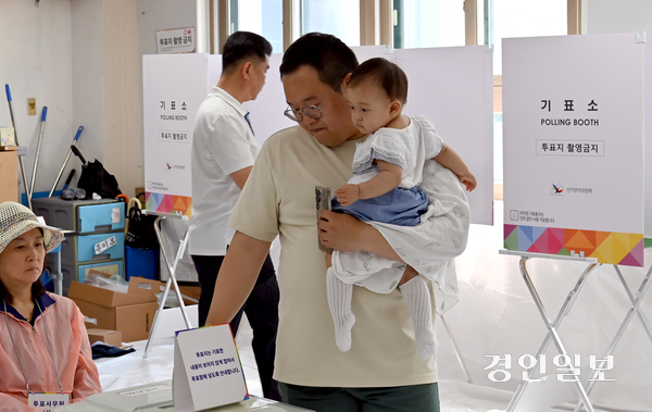 제21대 대통령선거일인 3일  인천시 미추홀구 용현중학교에 마련된 용현5동 제5투표소에서 한 유권자가 아기를 안고 소중한 주권을 행사 하고 있다. 2025.6.3 /김용국기자yong@kyeongin.com