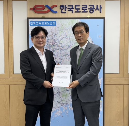 김병수(왼쪽) 김포시장이 지난 4일 함진규 한국도로공사 사장에게 계양~강화 고속도로 김포한강2콤팩트시티 구간 지하화와 IC 신설을 위한 건의문을 전달하고 있다. 2025.6.4 /김포시 제공