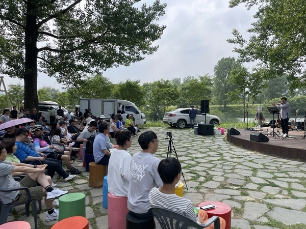 지난 7일 가평 자라섬꽃페스타를 찾은 시민들이 지역예술가의 대금 공연을 감상하고 있다. 2025.6.7 가평/김민수기자 kms@kyeongin.com