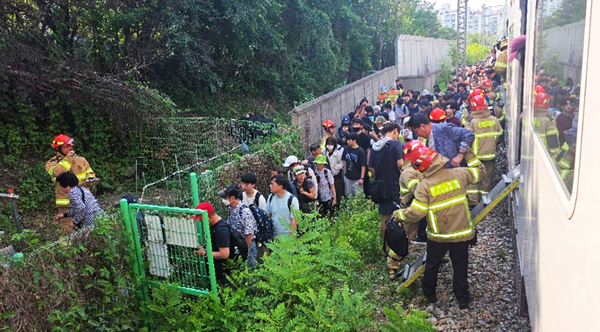 12일 오후 안양시 만안구 석수동 지하철 1호선 석수역 인근을 지나던 한 상행선 전동열차가 전력공급장치 고장으로 멈춰 서 승객들이 하차해 대피하고 있다. 2025.6.12 /경기도소방재난본부 제공