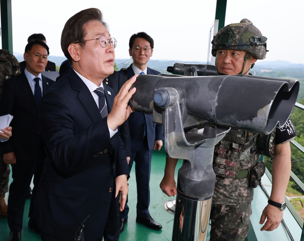 이재명 대통령이 13일 경기도 연천군 육군 25사단 비룡전망대에서 한기성 사단장의 설명을 들으며 망원경으로 북측 지역을 보고 있다. 2025.6.13 /연합뉴스