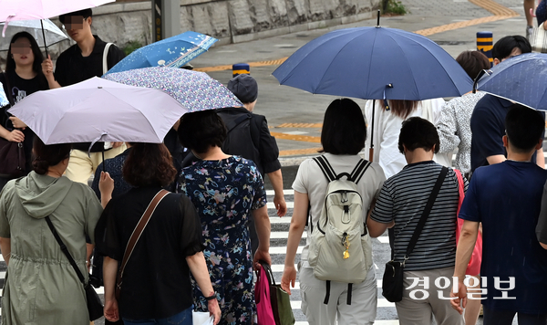 15일 기상청에 따르면 주말까지 경기 남부를 비롯해 전국에 많은 비가 내릴 것으로 예상된다. 사진은 지난 13일 우산을 쓰고 횡단보도를 건너는 시민들의 모습. 2025.7.13 /김용국기자 yong@kyeongin.com