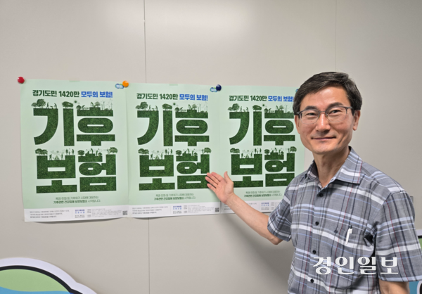 박대근 경기도 환경보건안전과장이 경기 기후보험 포스터를 가리키고 있다. 2025.7.15 /김태강기자 think@kyeongin.com