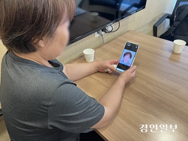 13일 오후 인천 부평구에서 만난 ‘부평 가정폭력 살인’ 피해자 최씨의 여동생이 언니의 사진을 바라보고 있다. 2025.7.13 /송윤지기자 ssong@kyeongin.com
