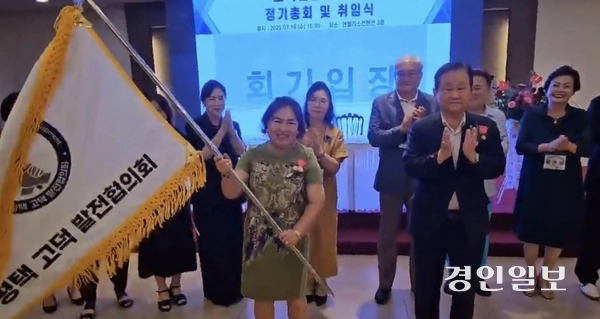 송윤순 평택 고덕 발전협의회 회장이 임원진들이 지켜보는 가운데 깃발을 흔들고 있다. 2025.7.16 평택/김종호기자 kikjh@kyeongin.com