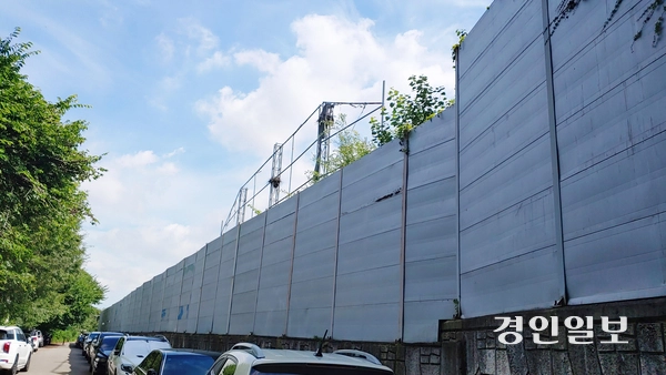 높은 담장으로 둘러싸여 외부와 철저하게 차단된 안양시 석수동 연현마을 인근 아스콘공장. 담장을 낀 좁은 길에는 무질서하게 주차된 차량들이 가득하다. 2025.7.23 안양/박상일기자 metro@kyeongin.com