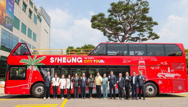 시흥 시티투어 버스 시범운행을 앞두고 최근 시 관계자들이 시티투어 버스 앞에서 기념촬영 하고 있다. /시흥시 제공