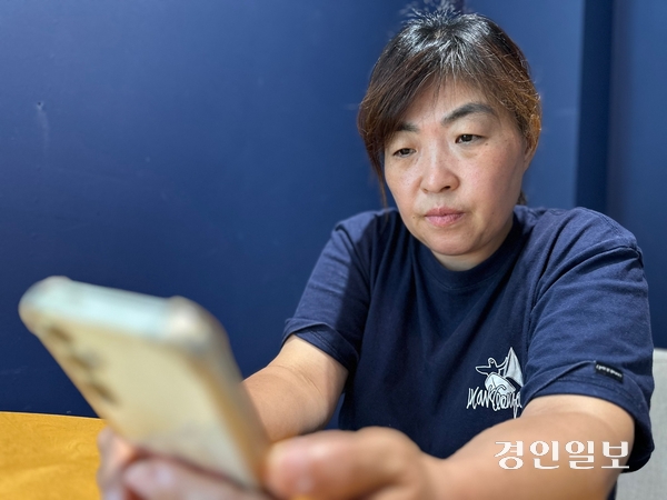 아리셀 참사로 남편을 잃은 최현주씨가 고인이 된 김병철 연구소장의 사진을 보고 있다.